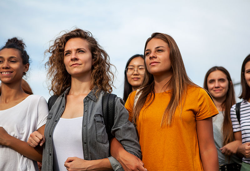 A group of women standing shoulder to shoulder